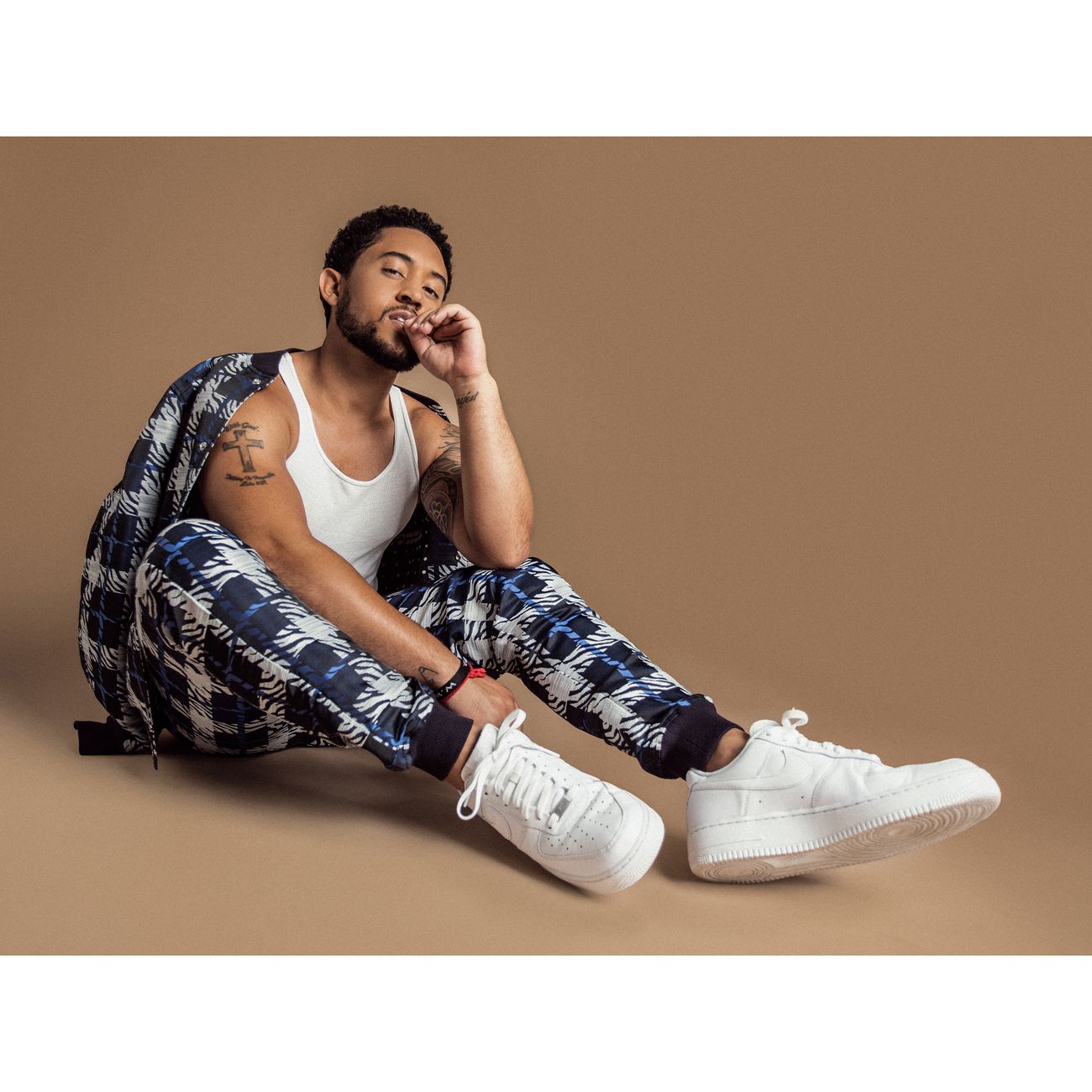 Menswear styling: printed drawstring trousers with a white tank and plaid layer